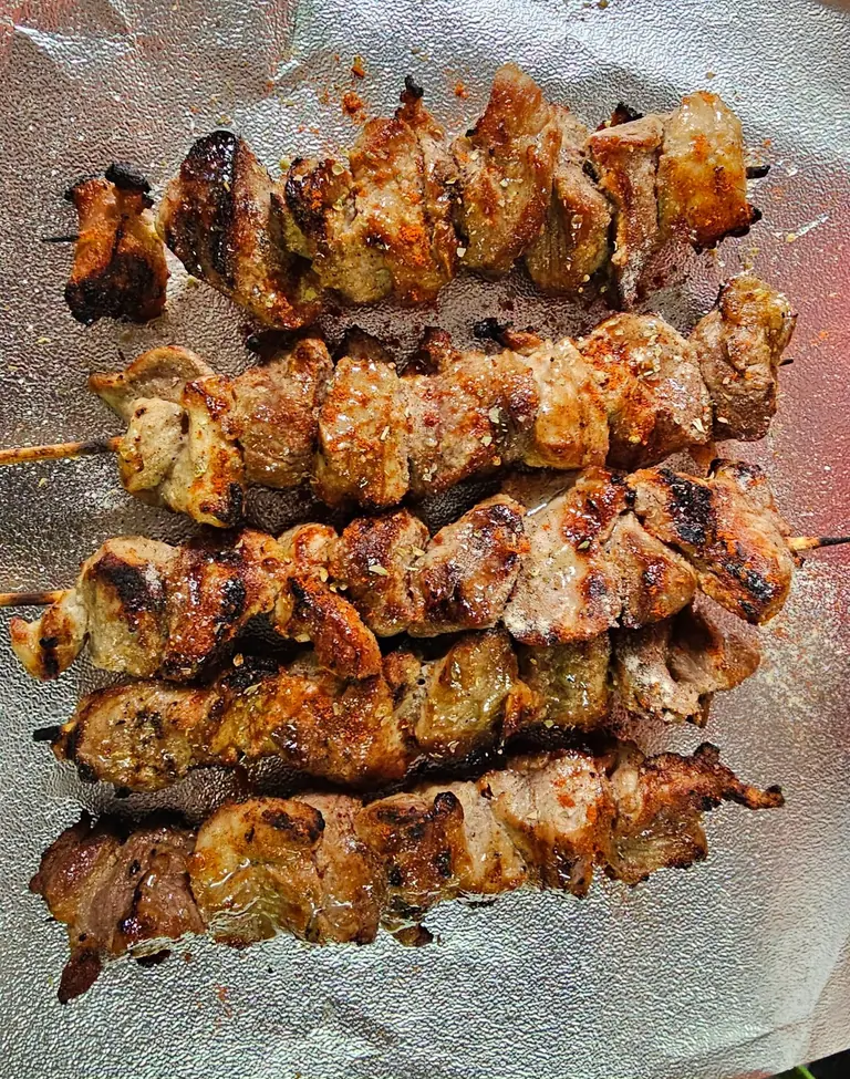 A close-up of Olympian souvlaki skewers with a deeply grilled crust